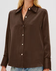 Brown button-up shirt worn by a person on a white background