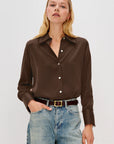 Woman wearing a brown button-up shirt and blue jeans on a white background