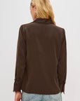 Person wearing a brown blouse and blue jeans on a white background back
