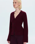 Woman wearing a burgundy cardigan on a white background side