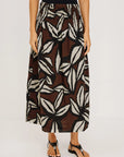 Person wearing a patterned skirt on a plain background