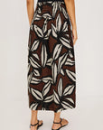 Person wearing a patterned skirt on a plain background