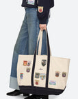 model holding a patchwork tote bag with jeans and boots on a white background