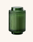 Green ribbed glass jar on a white background
