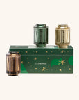 Three cylindrical containers with gold and green design on a green box labeled 'La Jolie Muse' against a white background.