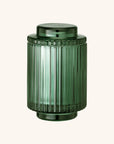 Green ribbed candle jar on a white background