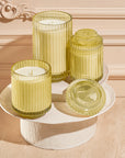 Set of yellow glass candles on a decorative stand with a beige background