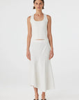 Woman wearing a white sleeveless top and skirt on a white background