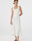 Woman wearing a white sleeveless top and skirt set on a white background
