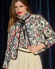 Woman wearing a floral patterned jacket and Angelina Skirt with a dark background