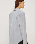 Woman wearing a striped shirt against a plain background