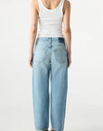 Person wearing a white tank top and light blue jeans on a white background, back