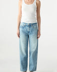Person wearing a white tank top and light blue jeans on a white background