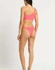 Model size XS wearing Lotus Brief in Coral Pink and Lotus Crop in Coral Pink, back