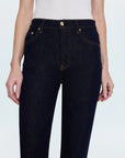 Dark blue jeans worn by a person on a white background detail view