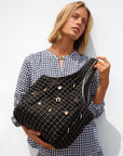 Woman holding a black textured handbag with decorative elements against a white background