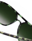 Sunglasses with green lenses and a distinctive frame design on a white background