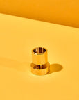 Gold cylindrical object on a yellow background