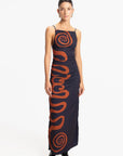 Woman wearing a long dress with a spiral pattern on a white background