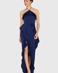 model wearing a dark blue ruffled dress on a white background