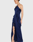 model wearing a dark blue ruffled dress on a white background