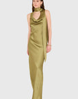 A woman models a sleeveless olive green satin dress with a draped cowl neckline and a long side drape, set against a solid light gray background.