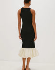 Black dress with a white ruffled hem on a white background back view