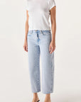 Person wearing a white t-shirt and light blue jeans on a plain background