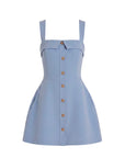 A light blue sleeveless mini dress with a structured, slightly flared silhouette, square straps, a pointed collar detail at the bust, and a central button-down front with gold-tone buttons.