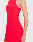 model wearing a red dress with ivory straps standing on a white background, side view
