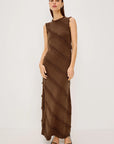 Woman wearing a brown sleeveless dress with fringe details on a white background
