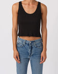 Person wearing a black tank top and blue jeans on a white background