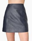 model wearing a leather mini skirt in navy on a white background