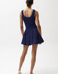 Person wearing a navy blue dress on a white background