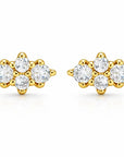 A pair of yellow gold stud earrings, each featuring a cluster of clear round-cut gemstones in a floral or snowflake-like arrangement, set against a plain white background.