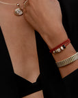 Cierra Cuff Bracelet close up on wrist with red bracelets