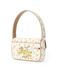 A Staud shoulder bag in beige canvas with brown leopard spots, featuring a yellow embroidered dog on a leash and the Staud logo.