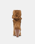 Tan suede boot with a pointed toe on a white background