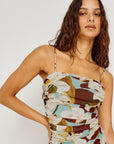 Woman wearing a floral strapless dress against a plain background