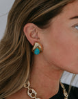 Model wearing laurel button earrings a gold necklace and a black top