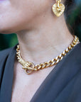 Gold chain necklace and heart-shaped earrings on a person