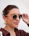 Woman wearing sunglasses with a plain background