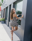 Back view of a woman in the Ivy Skort Bubble dress standing on a sidewalk next to a building