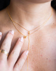 Close-up of a person wearing a delicate gold necklaces