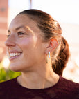 Woman with a side profile, wearing earrings, with a blurred background