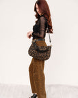 Woman holding a leopard print handbag against a white background, Miro Long Relaxed Jean side view