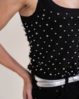 Black studded top worn by a person with a neutral background