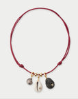 Necklace with shell charms on a red cord against a white background