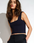 Woman wearing a black crop top against a white background