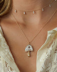 Necklace with a pendant worn by a person against a neutral background